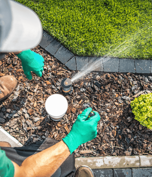 A lawn care employee at Stewart Grounds Management checking a sprinkler system.